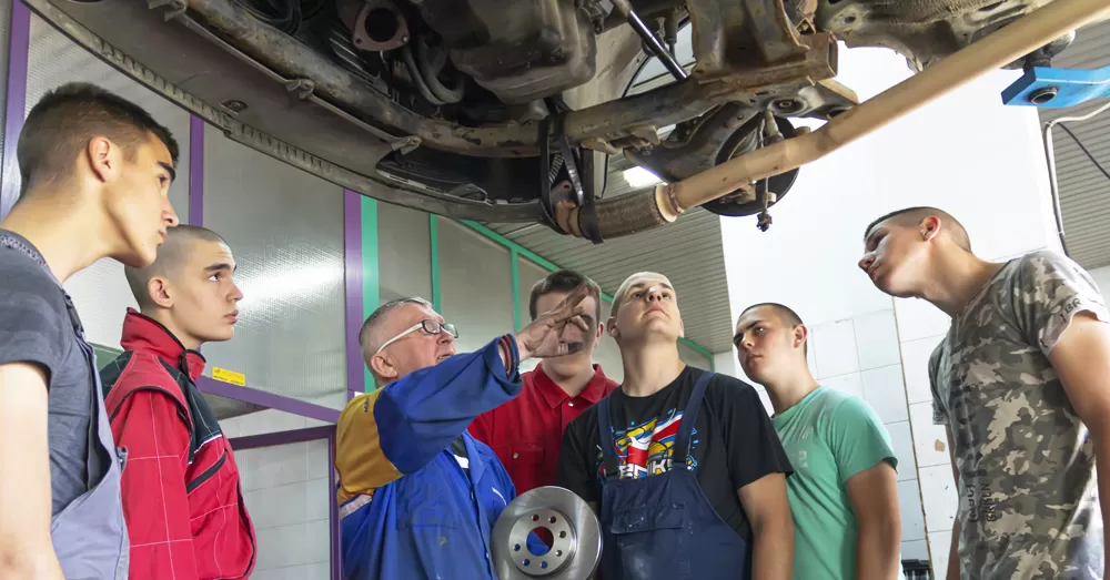 TAE40122 Certificate IV in Training and Assessment Course QLD students observing a trainer deliver hands-on automotive training — ideal for tradies and VET professionals looking to become qualified workplace trainers or assessors.